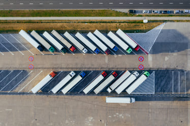 Overhead shot of semi trucks parked in a lot.