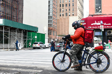 A delivery driver delivering food in the city.