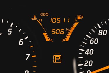 Close up on a orange speedometer in a car.