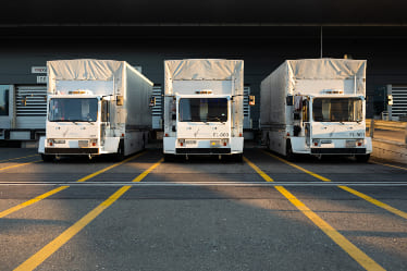 White trucks parked in a loading dock bay.