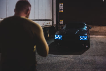 A person looking at a car to steal it.