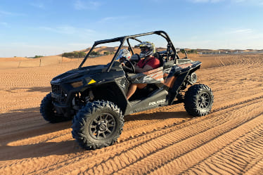 A dune buggy driving in the sand.