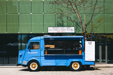 A temp controlled truck in front of a building.